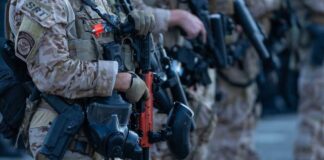 Law enforcement officers in tactical gear holding weapons