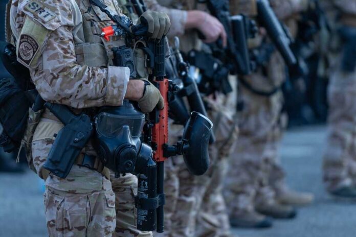 Law enforcement officers in tactical gear holding weapons