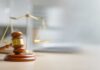 Federal Purge Tool ILLEGAL, Judge Slams Plan A wooden gavel and scales of justice on a desk