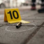 Bullet casing on the ground next to a numbered evidence marker