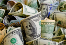 Mexican Immigrant’s $10K Decision Becomes Seven Figures Rolled U.S. dollar bills in various denominations.