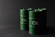 Green oil barrels on a dark background