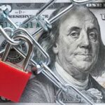 Price-Fixing Panic — States Get The Call A red padlock and chain over a hundred dollar bill featuring Benjamin Franklin