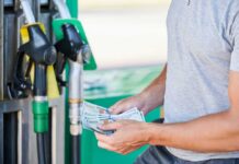 War Shock Hits Wallets Again Man holding cash at a gas station