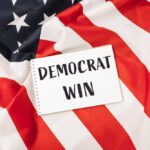 A notepad with the words 'DEMOCRAT WIN' placed on an American flag