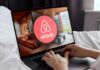 Airbnb’s July 4 Crackdown Sparks Fury Airbnb logo on a phone screen, near keyboard.