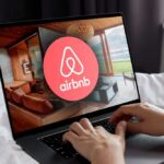 Airbnb logo on a phone screen, near keyboard.