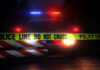 8 Dead: Bullets And Flames Inside Home Police car with flashing lights behind caution tape.