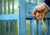 Record ICE Blitz Revealed — 43,138 Nabbed Hand unlocking blue metal door with keys.
