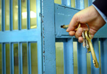 Record ICE Blitz Revealed — 43,138 Nabbed Hand unlocking blue metal door with keys.