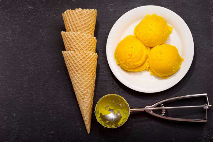 Ice cream scoops, cones, and scoop tool on black background.