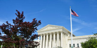 United States Supreme Court building with columns and an American flag