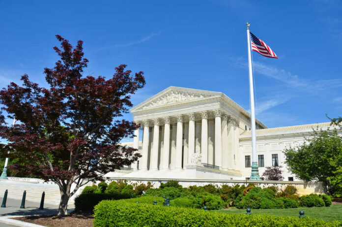 United States Supreme Court building with columns and an American flag