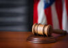 Bannon Wipeout Blocked — For Now A wooden gavel resting on a sound block with an American flag in the background