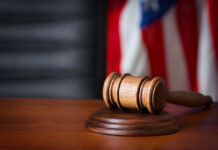 Bannon Wipeout Blocked — For Now A wooden gavel resting on a sound block with an American flag in the background