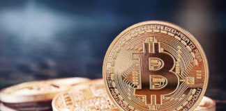 Bitcoin coins on a reflective surface.