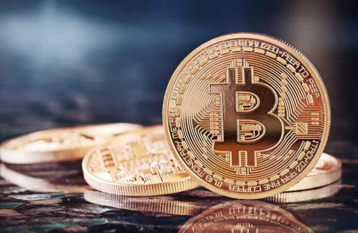 shutterstock_176573198 Bitcoin coins on a reflective surface.