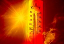 Thermometer displaying high temperature against a sunset background