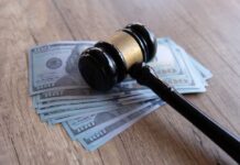Judge’s gavel resting on a stack of US hundred-dollar bills