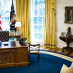 Raw Confession From Former First Lady Presidential office with desk, flags, and portraits.