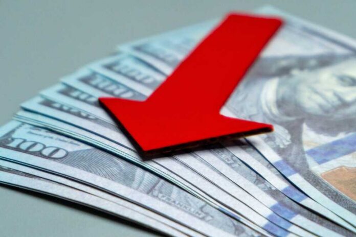 A,Red,Arrow,Pointing,Downwards,On,Top,Of,A,Pile Red downward arrow on U.S. dollar bills