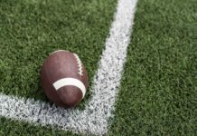 Football player in a red jersey kneeling on the field