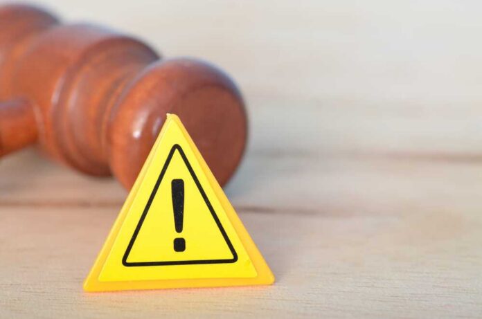 Yellow warning triangle with exclamation mark beside a wooden gavel
