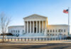 Supreme Court building with columns and U.S. flag
