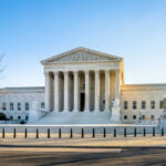 Supreme Court building with columns and U.S. flag
