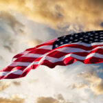 VIDEO: Team USA’s Record Rout Stuns World Cup American flag waving against a cloudy sky.