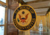 Six-Seat Blitz Shakes Key House Races U.S. House of Representatives seal on glass door.
