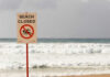 Tourist Photo Op Turns Deadly Trap Sign indicating the beach is closed with a no swimming symbol
