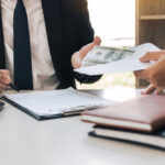Dead Paychecks Exposed — $99M Flagged Two individuals engaged in a business transaction involving money and documents