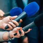 Media CFO Flips: Dirty Cash Fraud Revealed Reporters holding colorful microphones