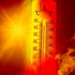 Thermometer showing high temperature against a blazing sun