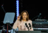 A woman speaks at a podium with microphones.