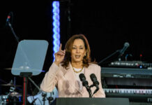 A woman speaks at a podium with microphones.