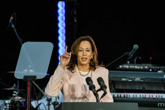 A woman speaks at a podium with microphones.