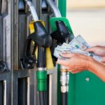 New Diesel Shock Slams Every Price Tag Person holding cash at a gas station while preparing to refuel