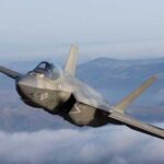 First-Ever Fighter Jet Shootdown Stuns Region F-35 fighter jet flying above clouds with mountains in the background