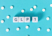 GLP-1 text on white cubes surrounded by white pills on blue background