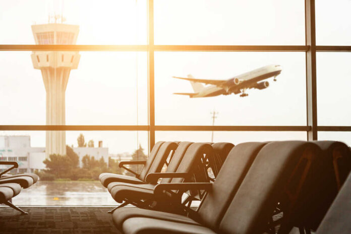 Empty,Chairs,In,The,Departure,Hall,At,Airport,,,With View of an airport terminal with an airplane taking off in the background