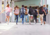 Children running with backpacks outside a school building.