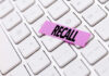Pet Food Recall Sparks Nationwide Alarm A pink sticky note with the word 'RECALL' placed on a white keyboard