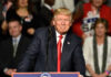 CEO’s Trump Love Bomb Jolts Leftists A man at a podium smiling during a rally.