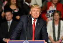 CEO’s Trump Love Bomb Jolts Leftists A man at a podium smiling during a rally.