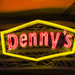 Dennys sign illuminated against a twilight sky