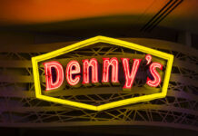 Dennys sign illuminated against a twilight sky