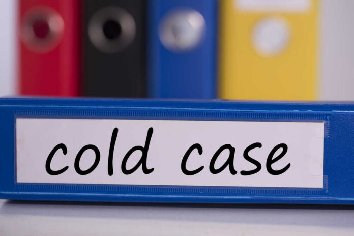 Blue binder labeled 'cold case' with other colored binders in the background