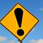 Trusted Coach EXPOSED Yellow caution sign with exclamation mark symbol.